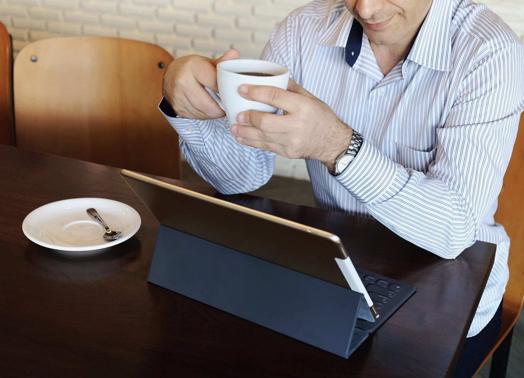 Man drinking coffee on laptop
